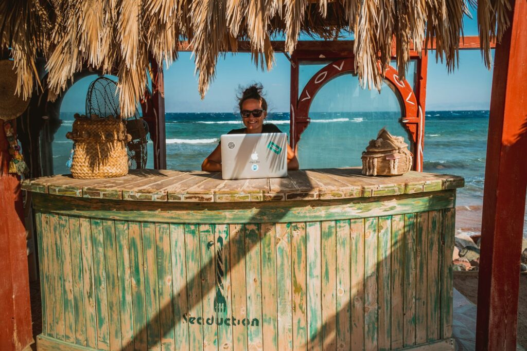 Digital nomad working on laptop with ocean view in the Caribbean.